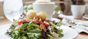 Gourmet mixed greens salad with succulent shrimp and herb-crusted goat cheese at Mad Hatter Cafe & Bakeshop in Durham